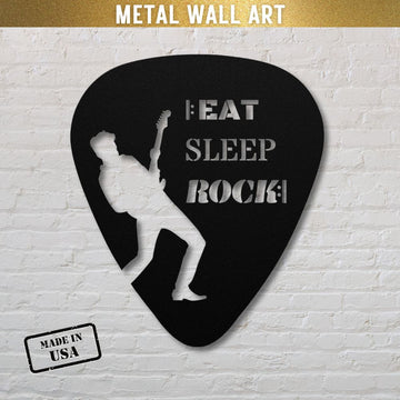 This guitar pick-shaped metal wall art, titled "Eat, Sleep, Rock, Repeat," features a guitarist's silhouette and the words "EAT SLEEP ROCK!" cut out. Made from durable powder-coated steel in the USA and available in multiple sizes and colors for both indoor and outdoor use, it makes an ideal gift for guitarists. It stands out beautifully against a white brick wall.
