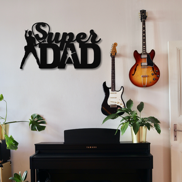 A wall with two guitars, green houseplants, a black Yamaha keyboard below, and the Super Guitarist Dad Sign | Metal Wall Art featuring silhouettes—a perfect music lover gift setup.