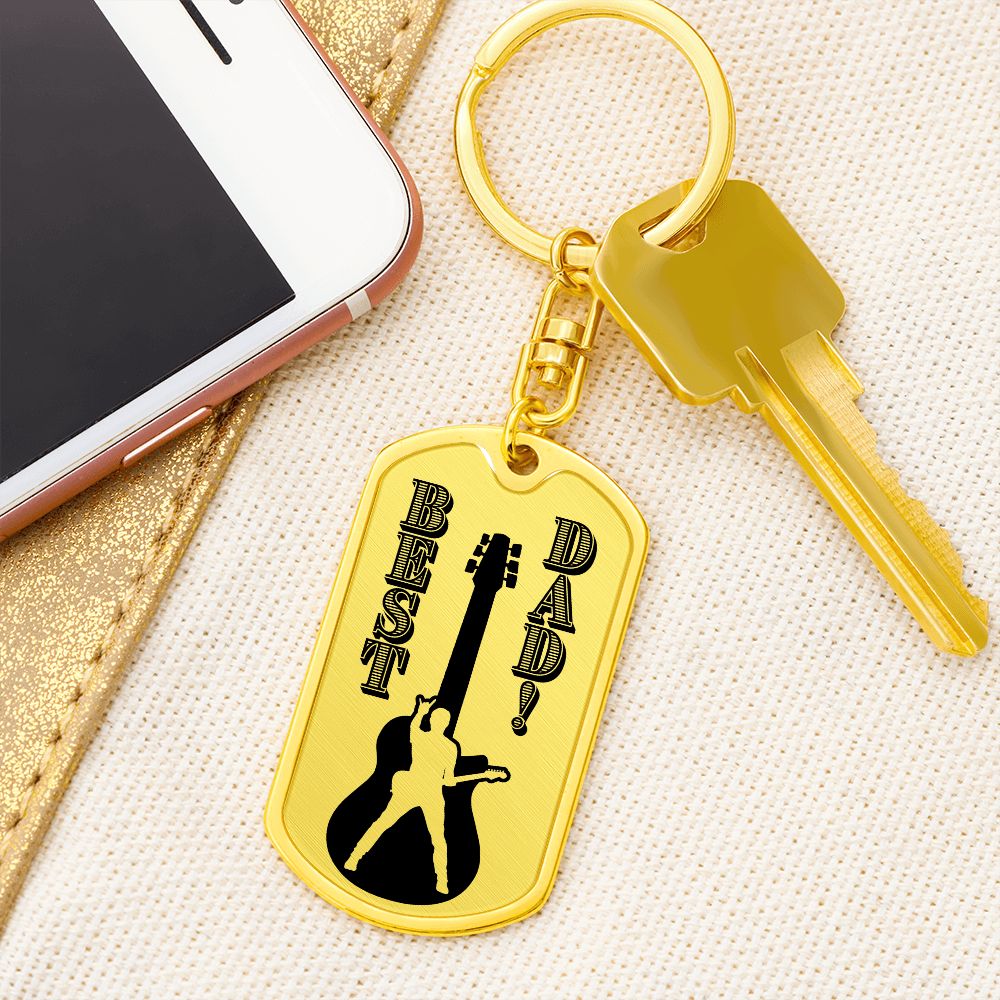 The Best Dad Guitarist Silhouette Dog Tag Keychain (SDT-DTK-0108) is a gold, military-style keychain engraved "BEST DAD!", featuring a guitar and person silhouette—an ideal personalized gift for any guitarist dad.
