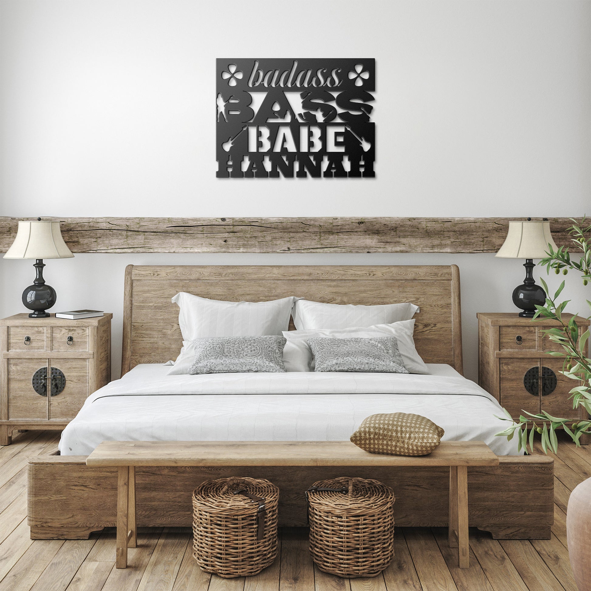 A rustic bedroom features a wooden bed, white bedding, nightstands with lamps, baskets under a bench, and the "Badass Bass Babe | CUSTOM Metal Wall Art for Female Bass Guitarist" sign above the bed—a cool gift for female bassists.