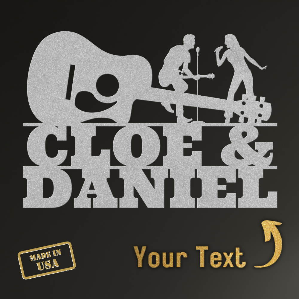 Silver silhouettes of a guitarist and singer stand above bold "CLOE & DANIEL" text, with a guitar shape in this powder-coated steel sign. Below: gold "Made in USA" label and custom gold "Your Text" with arrow on black. Singer & Guitarist Wall Sign MWA-MCS-0122.