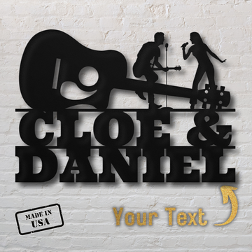 Singer & Guitarist Wall Sign with Custom Name (MWA-MCS-0122): Black metal art of a guitarist and singer above "CLOE & DANIEL", gold arrow, “Your Text” option, and “MADE IN USA.” Perfect personalized decor for music lovers.