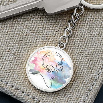 The Head Phones Colorful Circle Pendant Keychain features a line drawing of headphones over a vibrant watercolor backgroundβan ideal, personalized gift for any music lover.