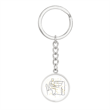 A silver keychain, the "Piano Gold Stars | Circle Pendant Keychain," features a round pendant with gold star accentsβan ideal engraved gift for any pianist.