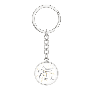 A silver circle pendant keychain featuring piano music notesβan ideal engraved gift for pianists.