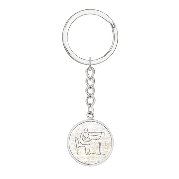 Silver personalized keychain with a round pendant engraved with piano sheet music. The textured, brushed background makes this circle pendant keychain a perfect gift for pianists and music lovers.