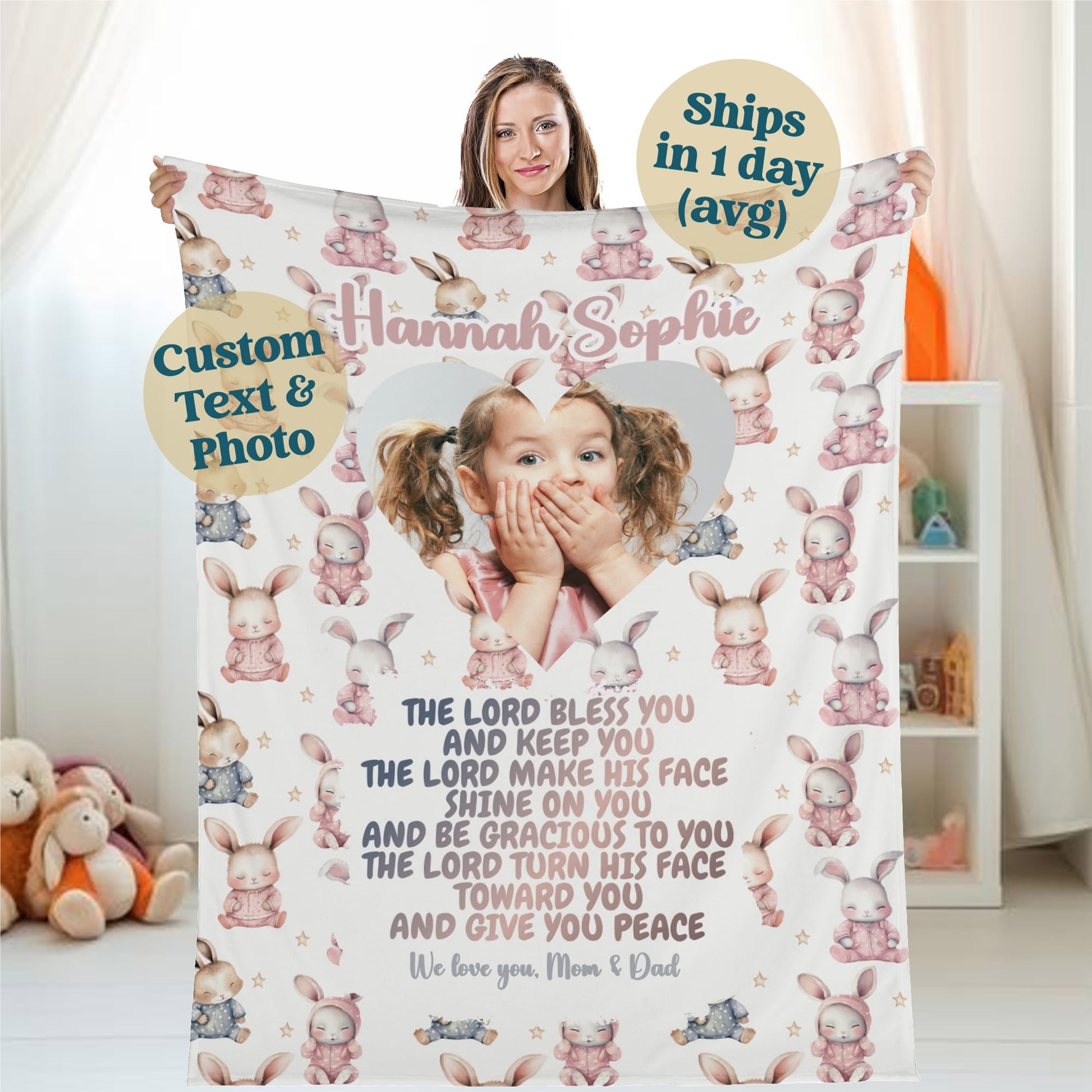 A woman holds a Personalized Baby Name Blanket featuring a child's photo and the name "Hannah Sophie." This customized blanket, embellished with bunny and heart designs, includes a heartfelt blessing. Promotional details emphasize its "Custom Text & Photo," promise to "Ships in 1 day (avg)," and express the message "We love you, Mom & Dad.