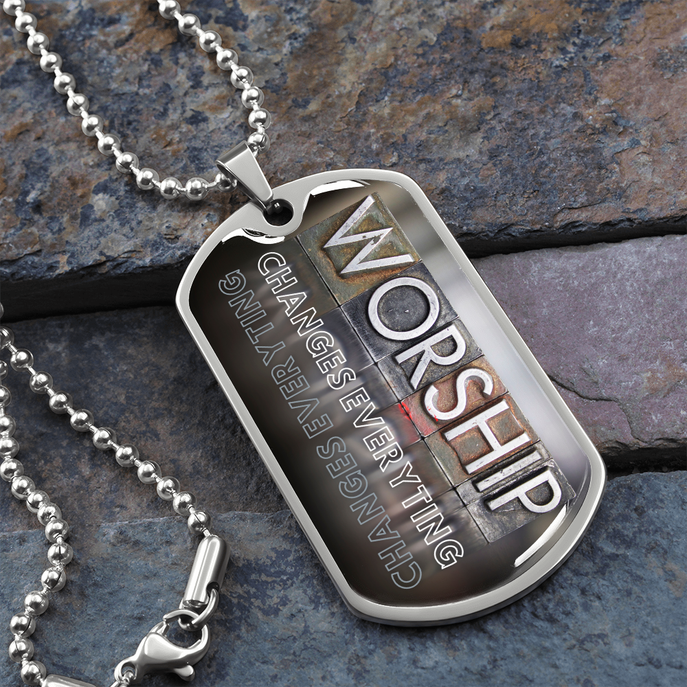 Silver worship dog tag necklace with bold vertical worship typography and “Worship Changes Everything” design on stone