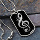A black dog tag necklace featuring a G-clef cutout and a vintage microphone design rests on a stone surface—a unique gift that any music lover will treasure. This personalized Dog Tag Necklace Black is perfect for engraving your custom message on the back, making it both stylish and meaningful.